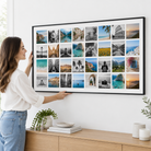 Frau hängt die Instawall Canvas Wide Fotoleinwand mit schwarzem Schattenfugenrahmen an die Wand